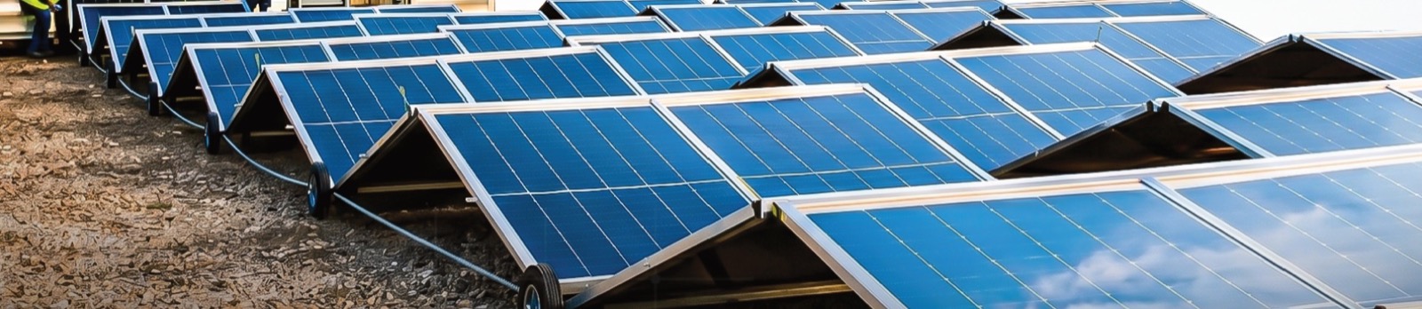 Rangée de panneaux solaires Nomad déployés sur roues à côté du conteneur